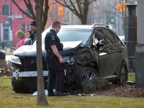 An officer examines a vehicle involved in a two-car crash on Dufferin and Clarence streets. MORRIS LAMONT/THE LONDON FREE PRESS