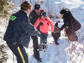 RCMP officers help a young boy at the Canadian border.