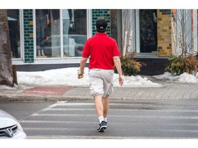 A pedestrian wearing only shorts and a golf shirt crosses Churchill St as the weather temperatures continue to be mild for the next few days. Wayne Cuddington / Ottawa Sun