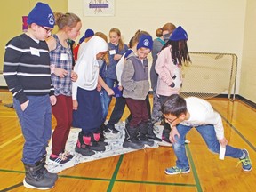 Students take part in the Synergy Blanket activity as part of the carnival games at Palliser Regional Schools’  “Be U(nique)” student leadership conference for students in Grades 4-6. Photo courtesy of Palliser Regional Schools