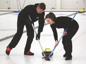 County Central High School students Jared Palaniuk and Emily Morse sweep a rock the morning of Tuesday, Feb. 14, when the school’s senior varsity mixed curling team played its first game of the South Zone curling championships in Lethbridge. Stephen Tipper Vulcan Advocate