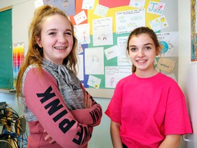 Luke Hendry/Th Intelligencer
Students Hannah Hoffman, left, and Olivia Millar stand in front of the "respect wall" at Holy Rosary Catholic School Wednesday in Belleville. It's covered with students' descriptions of ways in which they will be more respectful - one of many activities surrounding Pink Shirt Day, a campaign against bullying.