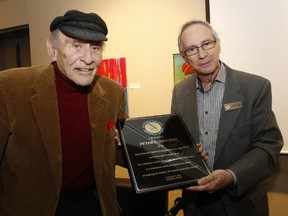 LUKE HENDRY/The Intelligencer
Author and Belleville resident Peter C. Newman, left, accepts a plaque of appreciation from Hastings County Historical Society president Richard Hughes during a reception in Newman's honour Thursday at the Belleville Public Library. Hughes said it was in recognition of Newman's "bringing history to the people."