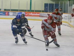 Justin Karcz, left, of College Notre-Dame, and Justin Gibeault, of St. Charles Cardinals, battle for the puck during game one of the division 1 boys high school hockey final at the Gerry McCrory Countryside Sports Complex on Thursday. John Lappa/Sudbury Star