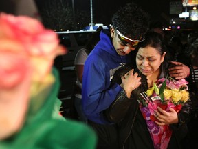 Max Vasquez, brother of 18-year-old Subway employee Javier Flores, and his mother put flowers at the make-shift memorial at the vigil prepared for Flores Thursday, Feb. 23, 2017, in Houston. Police say Flores and his mother were the only people working in the southeast Houston Subway restaurant near closing time Wednesday night when two assailants rushed in and pointed a gun at the woman. Detective David Crowder says Flores "attempted to push (her) out of the way as the suspect was firing, and he was hit and the mother was not." (Yi-Chin Lee/Houston Chronicle via AP)