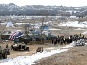 Law enforcement enters the Oceti Sakowin camp to begin arresting Dakota Access Pipeline protesters in Morton County, Thursday, Feb. 23, 2017, near Cannon Ball, N.D. As the arrests were underway law enforcement personnel drove several large construction equipment into the camp to begin the cleanup process of razing tents and structures. (Mike McCleary/The Bismarck Tribune via AP, Pool)