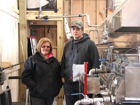 Judy Aldred and her son Scott stand next to their brand new evaporator, which they will use to produce maple syrup at their farm.