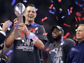 In this Feb. 5, 2017, file photo, New England Patriots' Tom Brady holds the Vince Lombardi Trophy beside coach Bill Belichick, right, after the Patriots defeated the Atlanta Falcons 34-28 in overtime at the NFL Super Bowl 51 football game in Houston. A new book and a movie are in the works about Brady and the suspension he overcame to earn an unprecedented fifth Super Bowl ring. (AP Photo/Darron Cummings, File)