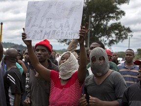 South Africans wave anti-immigration placards during a protest in Pretoria, South Africa, on Friday, Feb. 24, 2017. (AP Photo/Yeshiel Panchia)