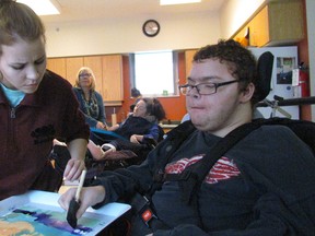 Hailey Maxwell, with Community Living Sarnia-Lambton, helps Bill Benson with a watercolour Friday during the Hands On Art program at Standing Oaks in Sarnia. Benson, and other residents of a Community Living residence, were visiting Standing Oaks for the weekly art program provided by Community Concerns for the Medically Fragile. Hands On Art is holding an art exhibition during March at the Lawrence House Centre for the Arts, opening on First Friday, March 3. (Paul Morden/Sarnia Observer)