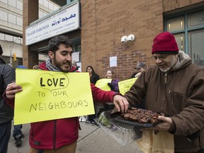 Gustavo Carlos is offered a date square outside Masjid Toronto, where a prayer was taking place on Friday, Feb. 24, 2017. (CRAIG ROBERTSON/TORONTO SUN)