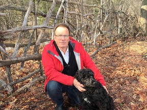 Anthony Thomson and his dog Charlie in Kingston in front of a section of the 700-yard wattle fence Thomson has been building at Cataraqui Golf and Country Club the past five years. (Mike Norris/The Whig-Standard)