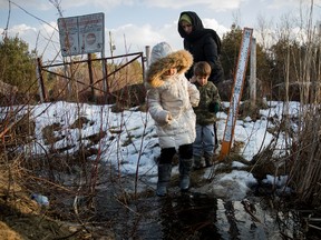 A family from Turkey crosses the U.S.-Canada border into Canada on Thursday near Hemmingford, Que. In the past month, hundreds of people have crossed the border away from official crossings in attempts to seek asylum in Canada. (Drew Angerer/Getty Images)