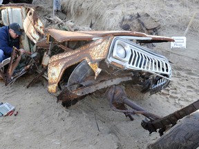 John Musnuff looks through the rubble of the old family Jeep after it was pulled out of the collapsed storage shed Friday, Feb. 24, 2017, in Truro, Mass. Work crews early Friday pulled out the rusted remnants of what John Munsnuff says was once his family’s “beach buggy” at the home they’ve long owned near Ballston Beach in Cape Cod. (Steve Heaslip/The Cape Cod Times via AP)