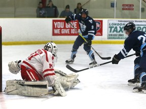 Nathan Devereux of the Lucas Vikings slips a backhand past the outstretched Jordan Garrow of the Medway Cowboys during Game 3 of their best-of-three Thames Valley Central semifinal series at Nichols Arena on Friday. After falling behind 2-0 in the first period, the Vikings rallied for a 6-3 win. Lucas faces Oakridge in the Thames Valley Central championship series, starting Monday at Thompson Arena.  (MIKE HENSEN, The London Free Press)
