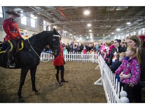 Large crowds came out to take a look at the RCMP Musical Ride's open house at the RCMP Rockcliffe Stables Saturday February 25, 2017. Far right - Jen Lafortune with four year old Eva and seven year old Ben take a close look at one of the horses on display Saturday morning.