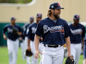 Braves pitcher R.A. Dickey walks to the main field with teammates during a spring training workout in Kissimmee, Fla., on Tuesday, Feb. 21, 2017. (John Raoux/AP Photo)