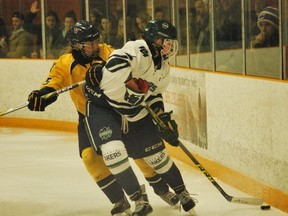Lady Vees' MacAuley Carr battles for a puck with a unidentified Nipping Lakers player during Game 2 of a OUA women's hockey quarterfinal series at Gerry McCrory Countryside Sports Complex on Saturday. The Lady Vees won 4-3, forcing a deciding Game 3 Sunday in North Bay, which the Lakers won 2-1. Keith Dempsey/For The Sudbury Star