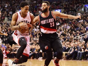 Toronto Raptors guard DeMar DeRozan drives between Portland Trail Blazers guard Damian Lillard and Trail Blazers guard Allen Crabbe during second half NBA basketball action in Toronto on Sunday, February 26, 2017. (THE CANADIAN PRESS/Frank Gunn)