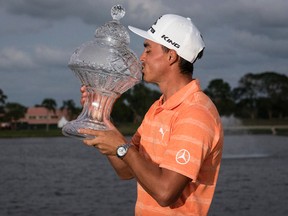 Golfer Rickie Fowler kisses the Honda Classic trophy after winning the final round of the Honda Classic golf tournament in Palm Beach Gardens, Fla., on Sunday, Feb. 26, 2017. (Michael Ares / The Palm Beach Post via AP)