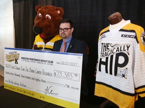 Justin Chenier, executive director of business operations for the Kingston Frontenacs, and team mascot Barrack The Bear unveil the final amount – $73,383.98 – raised by the auction of commemorative The Tragically Hip jerseys in Kingston, Ont. on Monday, Feb. 27, 2017. 
Elliot Ferguson/The Whig-Standard/Postmedia Network