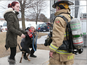 A fire was reported on the upper floors of 1244 Donald St. in Ottawa Monday Feb 27, 2017. Deanna Caillier gets a hug from her four month old puppy Odin after the Ottawa Fire Department rescued the animals from the building.  (Tony Caldwell, Postmedia)