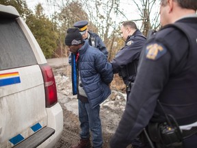 A man from the Democratic Republic of Congo is detained by RCMP officers after crossing the U.S.-Canada border near Hemmingford Que., Feb. 25, 2017. (GEOFF ROBINS/AFP/Getty Images)