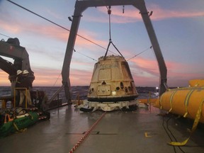 In this Tuesday, Feb. 10, 2015 file photo made available by SpaceX, their Dragon capsule sits aboard a ship in the Pacific Ocean west of Mexico's Baja Peninsula after returning from the International Space Station, carrying about 3,700 lbs of cargo for NASA. SpaceX announced Monday, Feb. 27, 2017 that it would send two paying customers to the moon next year on a private flight aboard its Dragon capsule. The company said the unnamed customers have paid “a significant deposit” for the moon trip.(AP Photo/SpaceX, File)