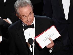 Presenter Warren Beatty holds up an envelope revealing "Moonlight" as the winner of best picture at the Oscars on Sunday, Feb. 26, 2017, at the Dolby Theatre in Los Angeles. (Photo by Chris Pizzello/Invision/AP)