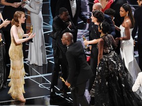 Jordan Horowitz, far left, producer of "La La Land," and cast member Emma Stone greet "Moonlight" cast members and filmmakers onstage after "Moonlight" was announced as the true winner of best picture at the Oscars on Sunday, Feb. 26, 2017, at the Dolby Theatre in Los Angeles. It was originally announced mistakenly that "La La Land" was the winner. (Photo by Chris Pizzello/Invision/AP)