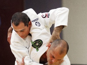 Royler (left) and Royce Gracie demonstrate a move during a jiu-jitsu seminar in Winnipeg on May 12, 2012. The Canada National Pro Jiu-Jitsu Championship in Montreal was cancelled last weekend after police threatened to arrest fighters as they considered the sport illegal prize fighting. (Brian Donogh/Postmedia Network/Files)