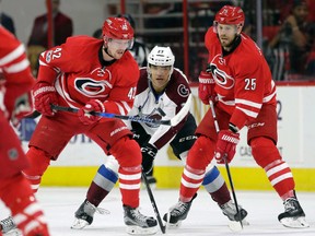 Carolina Hurricanes' Joakim Nordstrom (42), of Sweden, and Viktor Stalberg (25), of Sweden, chase the puck with Colorado Avalanche's Andreas Martinsen (27), of Norway, during the first period of an NHL hockey game in Raleigh, N.C., Friday, Feb. 17, 2017. (AP Photo/Gerry Broome)