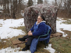 Jean Weeks, 72, sits by the tent in which she is living. She can’t live in her house because a woman to whom she rents space in her house has dogs and cats and Weeks is prohibited from living with animals by the Ontario Society for the Prevention of Cruelty to Animals. (Elliot Ferguson/The Whig-Standard)