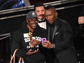 Mahershala Ali, right, takes a selfie with a tourist named Gary while holding his award for best actor in a supporting role for "Moonlight" at the Oscars on Sunday, Feb. 26, 2017, at the Dolby Theatre in Los Angeles. (Photo by Chris Pizzello/Invision/AP)