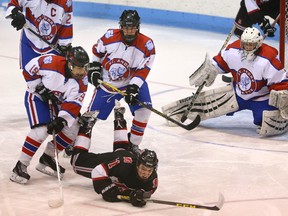 Brent Balles and John Geddes of the SAB Bulldogs take down Nate Vicory of the STA Flames in front of their goaltender Brock Macdonald during the second game of the AAA TVRA District final on Tuesday February 28, 2017 at Thompson Arena. SAB won 2-1 giving up one goal on a 5-3 power play in the third to tie the series at one, and will play for the championship on Thursday night. Mike Hensen/The London Free Press/Postmedia Network