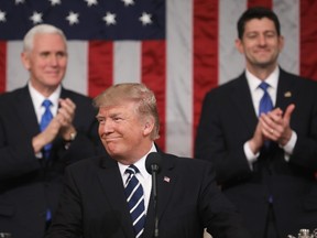 U.S. President Donald Trump (C) delivers his first address to a joint session of Congress from the floor of the House of Representatives in Washington, D.C., while Vice President Mike Pence (L) and Speaker of the House Paul Ryan (R) applaud in the background, Feb. 27, 2017. (JIM LO SCALZO/AFP/Getty Images)