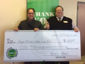 Dan Xilon, right, executive director of the Sudbury Food Bank, accepts a donation from John Maki. Supplied photo