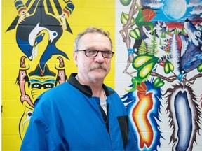 Charles Bastien poses for a photo with a mural he painted at the Fort Saskatchewan Correctional Centre in Fort Saskatchewan, Alta. on October 15, 2014. Photo by Ryan Jackson/Edmonton Journal/Postmedia Network