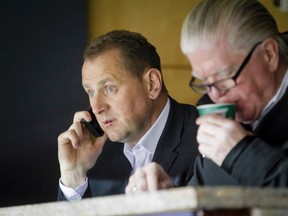 Calgary Flames general manager Brad Treliving watches a Flames practice next to Brian Burke, president of hockey operations, at the Scotiabank Saddledome in Calgary on Oct. 2, 2014. (Lyle Aspinall/Calgary Sun)