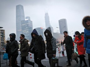 In this Feb. 21, 2017 photo, commuters, some wearing masks, walk to a subway station during the evening rush hour in Beijing. (AP Photo/Andy Wong)