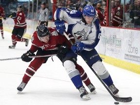 Sudbury Wolves Liam Dunda battles for the puck with  Ryan Merkley of the Guelph Storm during OHL action in Sudbury, Ont. on Friday December 30, 2016. Gino Donato/Sudbury Star/Postmedia Network