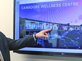 In this file photo, Canadore College president George Burton points to a feature on an artist's impression of the Village Living Wellness and Learning Centre.