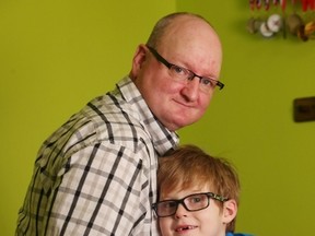Seven-year-old Grayson Powell and his father Todd pose at home in Conception Bay South, N.L. on Wednesday, March 1, 2017. A Newfoundland family is upset after a seven-year old boy was denied a gold medal in bowling due to the shade of his trousers, but the official involved says he simply enforced the sport's "classy" black pants tradition. (THE CANADIAN PRESS/Paul Daly)
