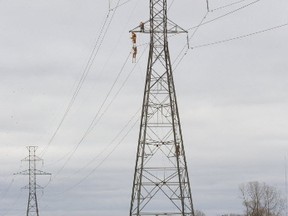Workers from Hydro One have a good view of Hwy. 401 as they work high on a transmission tower, near London, Ont. (MIKE HENSEN, Postmedia Network)