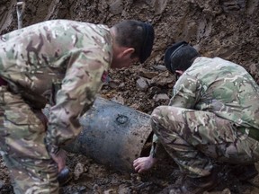 In this image taken Thursday March 2, 2017 released by the Ministry of Defence shows a Second World War bomb which was discovered on a building site in Brent, north-west London. British Army bomb disposal team were called in to dispose of a 500-pound World War II bomb found buried on a building site in northwest London. Schools, businesses and homes were evacuated and roads closed as experts from the Army's Royal Engineers to make the German bomb safe. (Rupert Frere/MoD via AP)