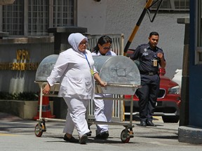 Medical staff wheel a casket trolley from the forensic department at the Kuala Lumpur Hospital in Kuala Lumpur, Malaysia on Friday, March 3, 2017. Malaysia said it would release and deport a North Korean man arrested in connection with the death of Kim Jong Un's half-brother due to a lack of evidence and announced it would scrap visa-free travel for citizens of the reclusive state. (AP Photo/Daniel Chan)