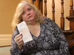 Allison Gibson holds a receipt for a meal from a London Wendy's restaurant, where she said she left a bag containing more than $3,500 of cash in the bathroom. Gibson said the money was rent payments she'd collected to pay the owner of her Dundas Street apartment building. DALE CARRUTHERS / THE LONDON FREE PRESS
