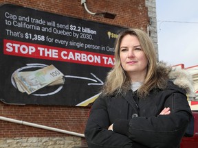 Christine Van Geyn, the Ontario director for the Canadian Taxpayers Federation, stands next to a billboard in the Springer Memorial parking lot in downtown Kingston that opposes Ontario's cap-and-trade program. (Ian MacAlpine/The Whig-Standard)