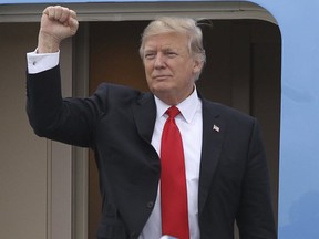 President Donald Trump gestures from the stairs of Air Force One upon his arrival at Palm Beach International Airport in West Palm Beach, Fla. Friday, March 3, 2017. (AP Photo/Luis M. Alvarez)