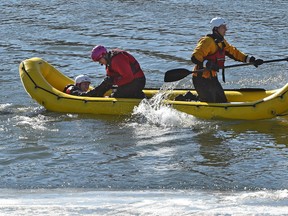 A rescuer pulls the victim out of the water as firefighters from station 6 practice various forms of rescue as part of their annual swift water ice training exercise along the North Saskatchewan River across from Rundle Park in Edmonton, Friday, March 3, 2017. Ed Kaiser